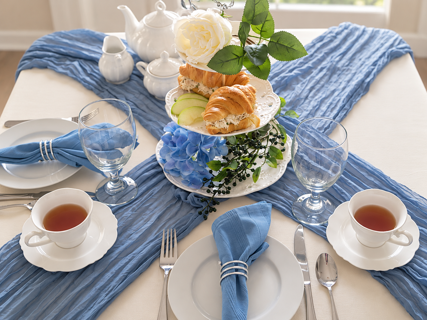 Bloom and Grace table styled with cream linens, dusty blue runners, white china and tea service